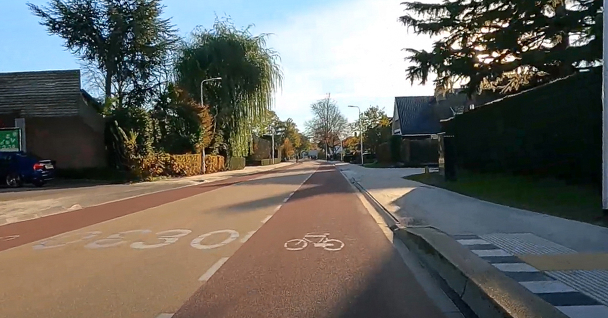 Een weg ingericht als een GOW30 met een geel geasfalteerde rijbaan en aan beide kanten een rode fietsstrook.